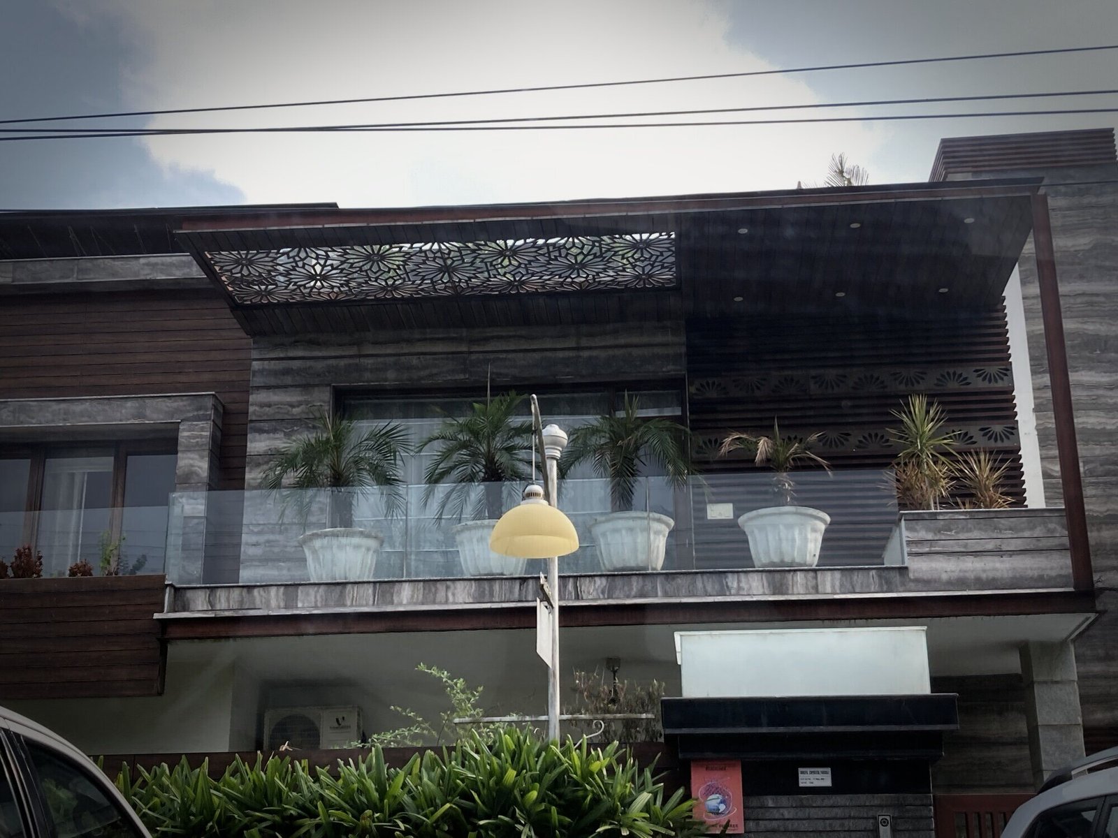 Façade with glass balcony and timber canopy